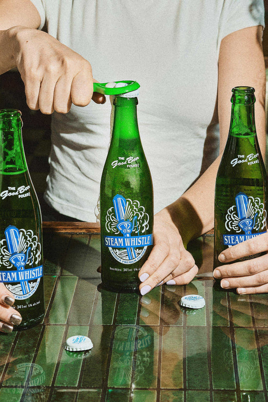 3 bottles of Steam Whistle Pilsner being opened